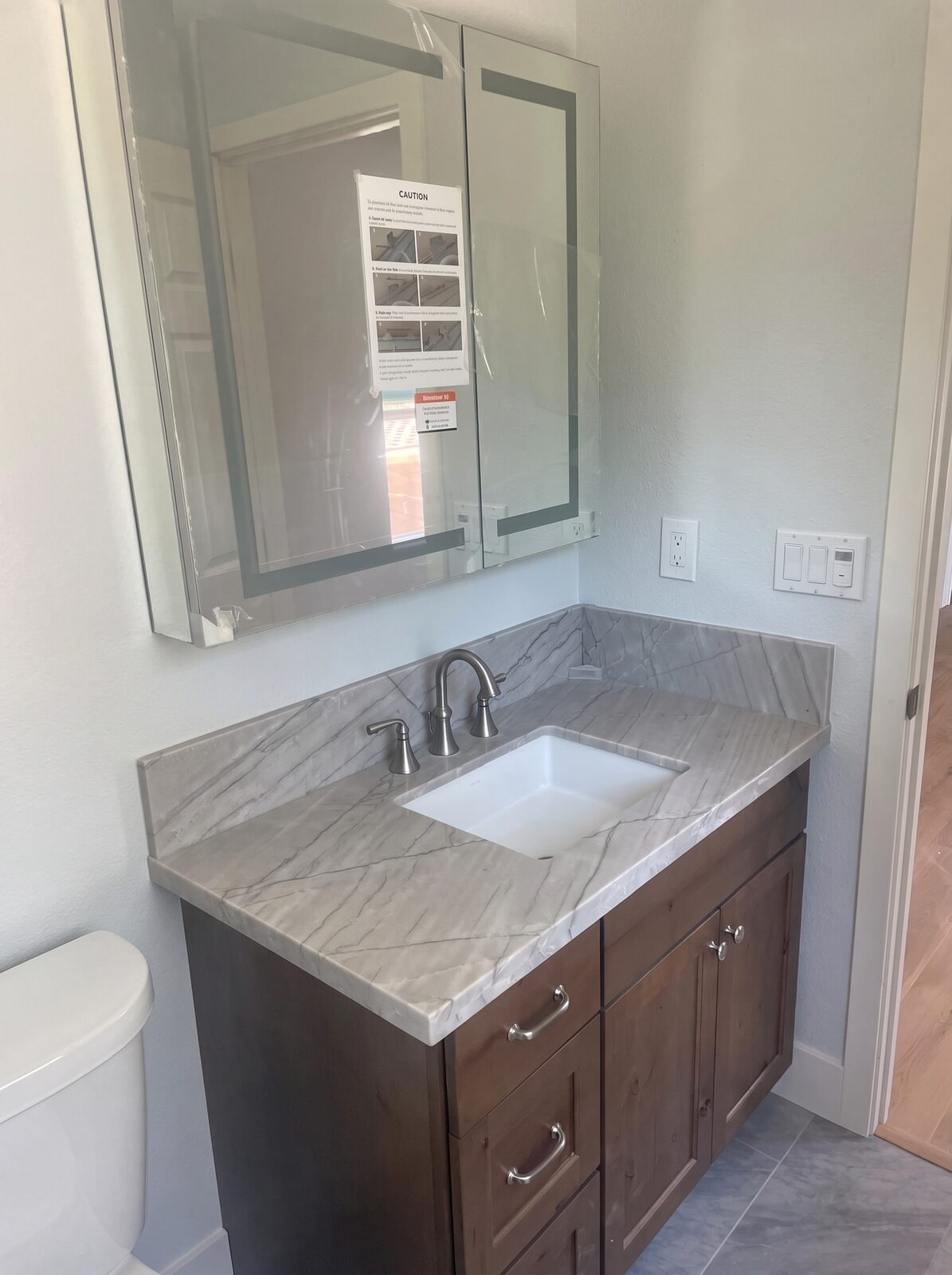 Bathroom vanity with stone countertop, undermount sink and wood cabinet