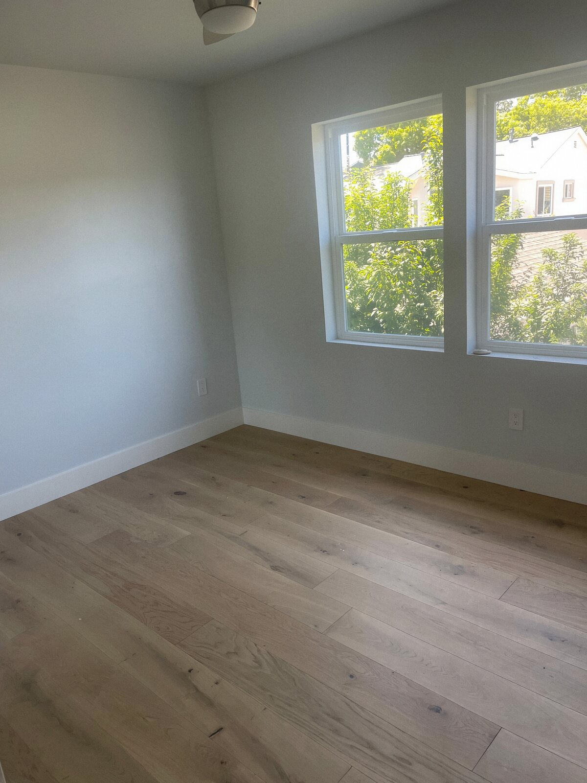 Bedroom with new wide-plank oak flooring, fresh paint and double windows